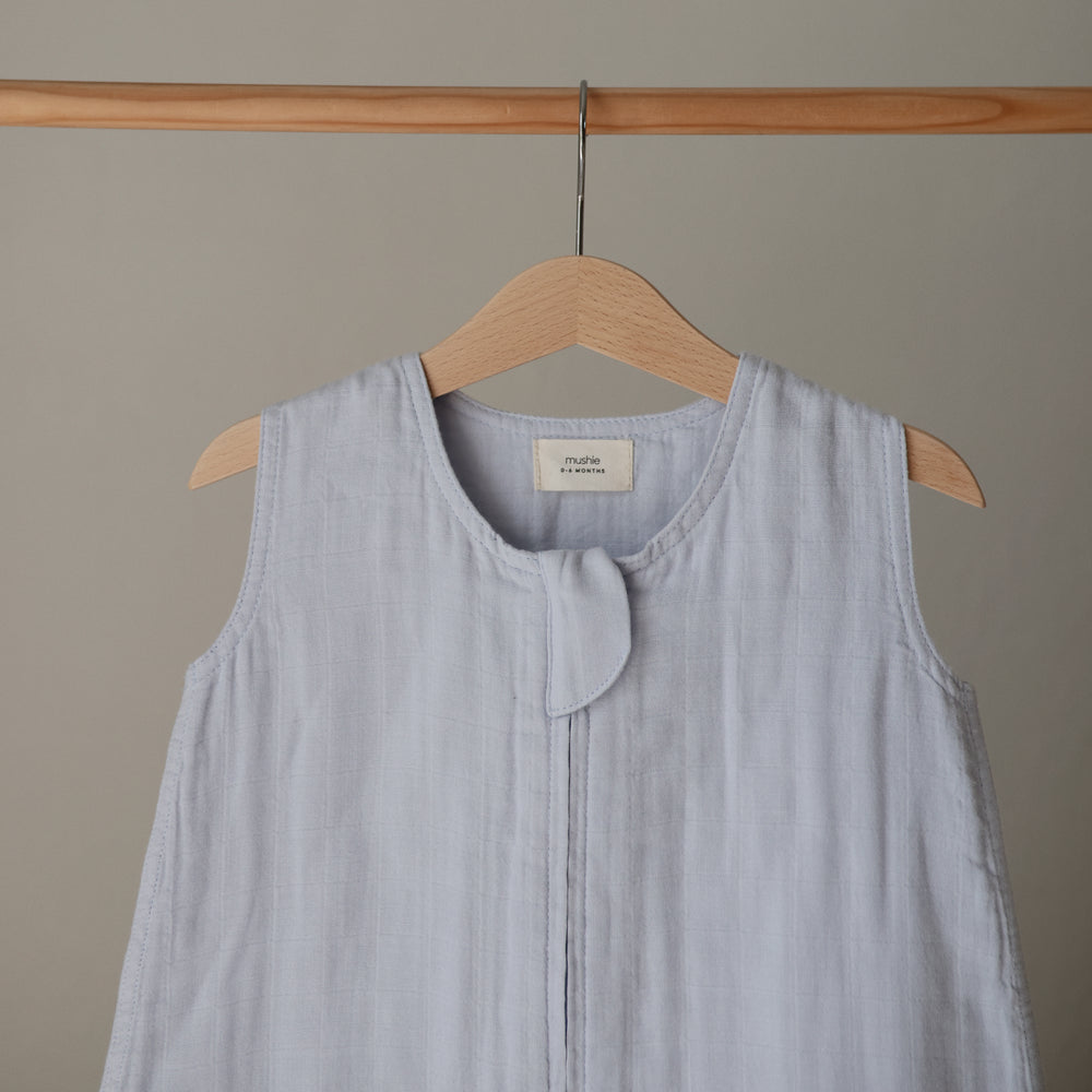 Lifestyle image of a Mushie Sleep Bag in Baby Blue on a hanger.